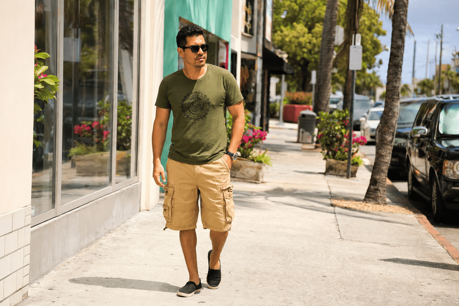 Hombre con camiseta verde gráfica, shorts cargo beige y calzado casual